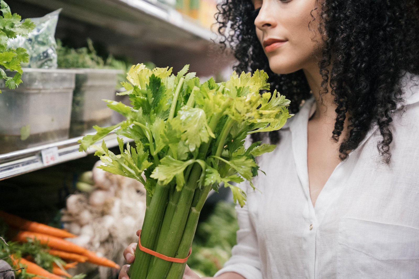 Close up of a Woman Holding a Celery Stalk with electrolytes