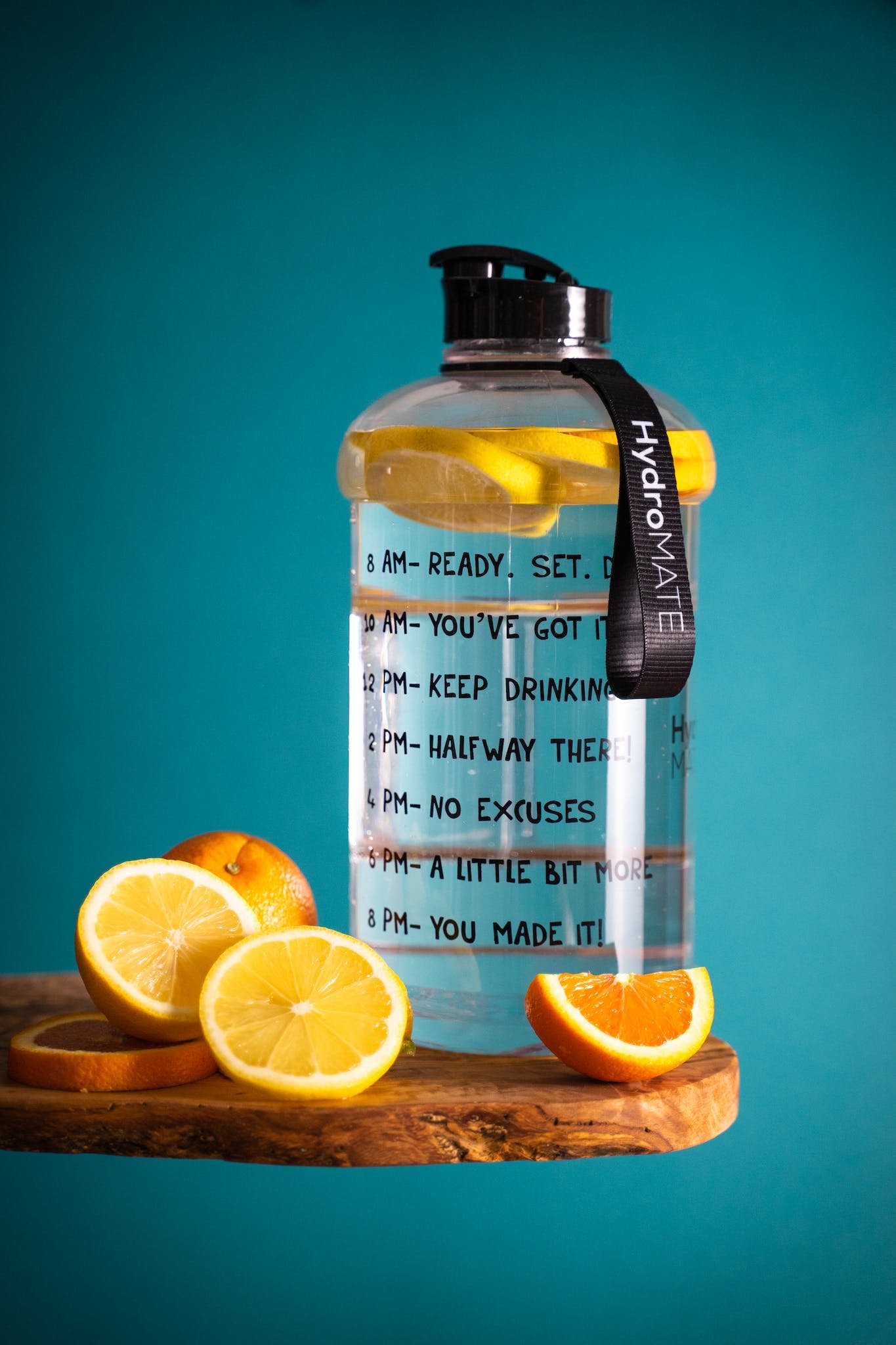 Slice Lemon Beside Glass Pitcher with time markers on Wooden Table