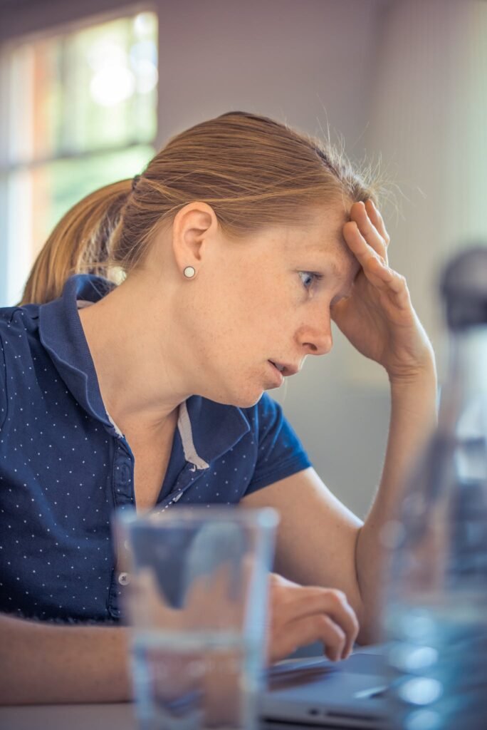 Woman Sitting in Front of the Laptop Computer With Headaches in Shallow Photo 