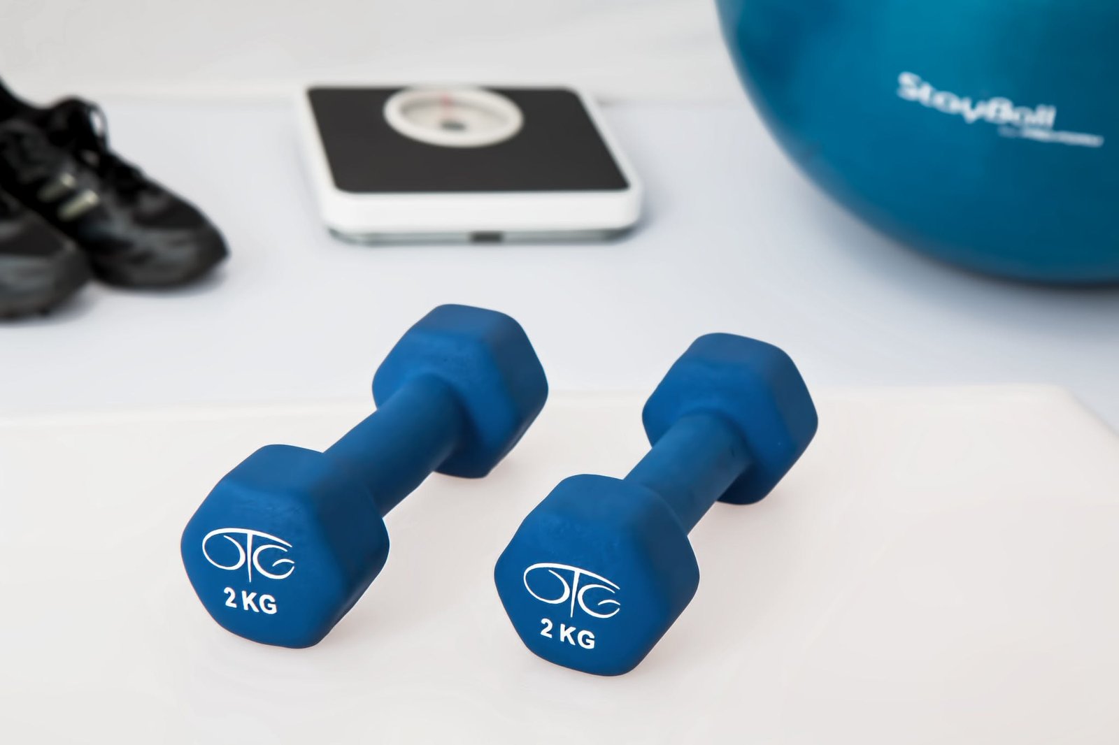 Two 2 Kg. Blue Hex Dumbbells on White Surface